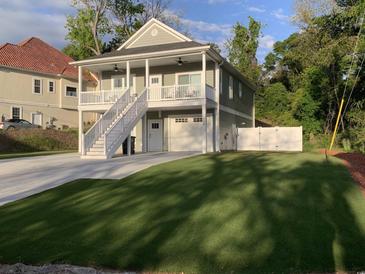 Charming two-story home with a double porch, white picket fence, and well-manicured lawn at 223 S 9Th Ave. S, North Myrtle Beach, SC 29582