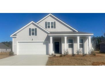 Charming single-Gathering home featuring a 2-car garage, a covered front porch, and classic architectural details at 418 Glade Ct., Loris, SC 29569