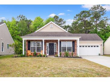 Charming brick home with a welcoming front porch and well-maintained lawn, featuring two wooden chairs at 4697 Farm Lake Dr., Myrtle Beach, SC 29579