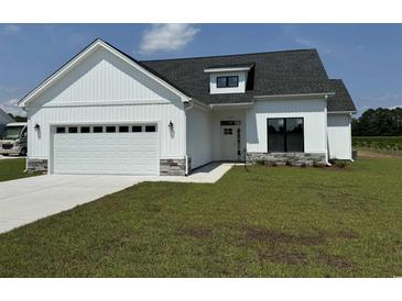 Charming new construction home featuring a two-car garage and beautifully manicured lawn at 4971 Dupont Rd., Aynor, SC 29511