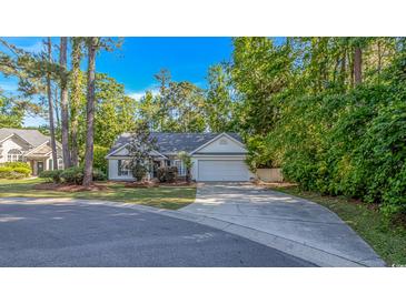 Charming single-story home with a well-maintained lawn and a driveway leading to an attached two-car garage at 5 Old Barge Dr., Pawleys Island, SC 29585