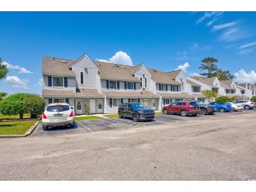 Inviting townhomes featuring neutral siding, complemented by convenient parking spaces and attractive landscaping at 500 Fairway Village Dr. # 7-C, Myrtle Beach, SC 29588
