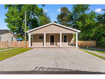 Charming single-story home features a covered porch with white pillars and a large concrete driveway at 509 S Rosemary Ave., Andrews, SC 29510