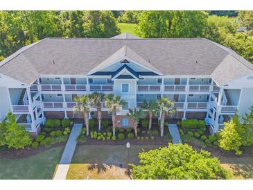 Aerial view of condo with nice balconies, palm trees, and well-maintained landscaping at 5801 Oyster Catcher Dr. # 1621, North Myrtle Beach, SC 29582