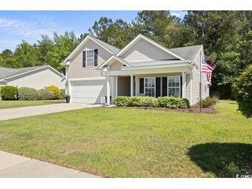 Charming home featuring a manicured lawn, classic siding, and an attached two-car garage at 680 Twinflower St., Little River, SC 29566