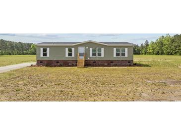 Charming one-story home with green siding, brick foundation, and inviting front steps at 7019 Norton Rd., Green Sea, SC 29545