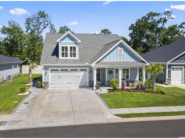 Charming two-story home with light blue siding, an attached two-car garage, and well-manicured landscaping at 1010 Graybill Lane, North Myrtle Beach, SC 29582