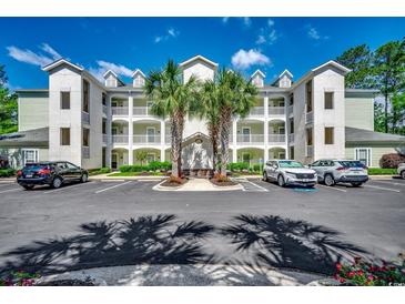 Inviting condo building with palms, multiple levels, ample parking, and a manicured landscape at 116 Cypress Point Ct. # 302, Myrtle Beach, SC 29579