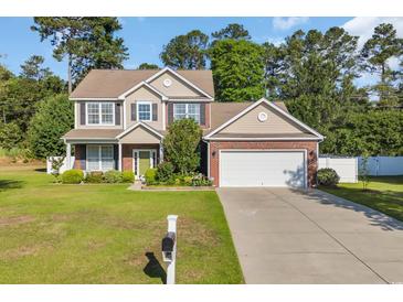 Charming two-story home with a manicured lawn and inviting curb appeal showcasing the traditional facade and attached garage at 140 Zinnia Dr., Myrtle Beach, SC 29579