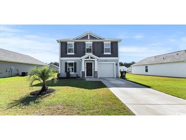Charming two-story home boasts manicured lawn, attached garage, and classic architectural details at 153 Foxford Dr., Conway, SC 29526