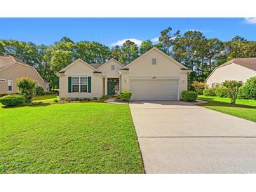 Charming single-story home with a well-manicured lawn, attached garage, and inviting curb appeal at 1617 Tradition Club Dr., Pawleys Island, SC 29585