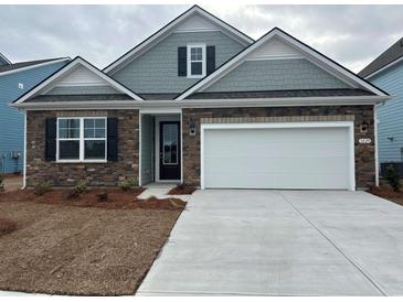 Charming single-Gathering home featuring a stone facade, light blue accents, a two-car garage, and a concrete driveway at 1836 Hardwood Ct., Conway, SC 29526
