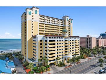 Exterior shot of a large yellow condo building with multiple floors and parking garage in Myrtle Beach, South Carolina at 2000 N Ocean Blvd. # 301, Myrtle Beach, SC 29577