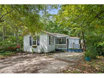 Charming single-story home with a cozy front porch and a well-maintained, landscaped yard at 2128 Adams Circle, Little River, SC 29566