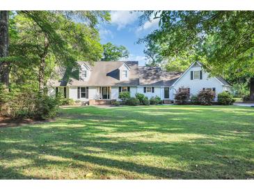 Charming home with a well-manicured lawn, mature trees, and a classic design at 217 Myrtle Ln., Myrtle Beach, SC 29572
