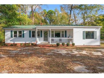 Charming single story home with white siding, green shutters, and a welcoming front porch at 3934 North Fraser St., Georgetown, SC 29440
