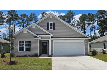 Charming single Gathering home with a two car garage and neutral colored siding and manicured front yard at 411 Acosta Circle, Conway, SC 29527