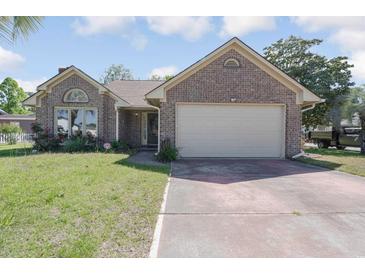 Charming brick home featuring a two-car garage and a well-maintained front yard with flowering plants at 4300 Cross Cut Trail, Myrtle Beach, SC 29579