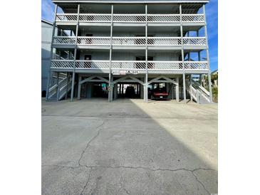 A multi-level condo building showcasing elevated construction and private covered parking at 625 North Waccamaw Dr. # 101, Murrells Inlet, SC 29576