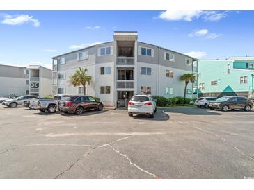 Three-story condo complex with ample parking, palm trees and outdoor stairwells at 6302 N Ocean Blvd. # G-3, North Myrtle Beach, SC 29582