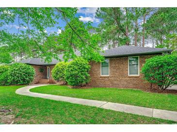 Charming brick home featuring a well-maintained lawn and a welcoming curved walkway at 8209 Timber Ridge Rd., Conway, SC 29526
