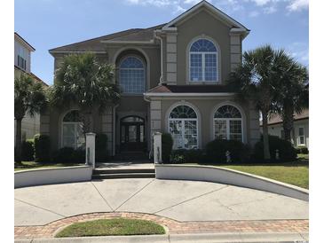 Elegant two-story home featuring arched windows, palm trees, and well-manicured landscaping at 837 Bluff View Dr., Myrtle Beach, SC 29579