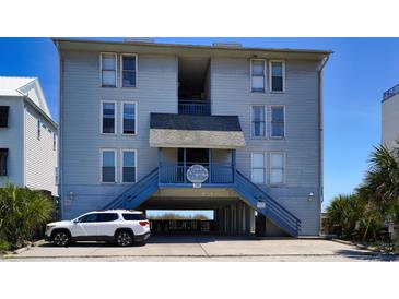 Beach condo building featuring covered parking and staircase access at 126 N Waccamaw Dr. # 101, Garden City Beach, SC 29576