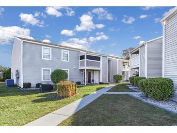 Charming condo complex featuring well-maintained landscaping and a serene setting with blue sky and white clouds at 1356 Glenns Bay Rd. # 208M, Surfside Beach, SC 29575