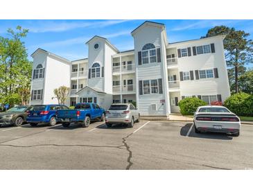 Three-story white condo building with black shutters and multiple parking spaces at 1525 Lanterns Rest Rd. # 103, Myrtle Beach, SC 29579