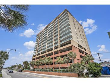 High-rise condo building with a parking garage surrounded by palm trees under a beautiful blue, partly cloudy sky at 1707 Perrin Dr. # 1003, North Myrtle Beach, SC 29582