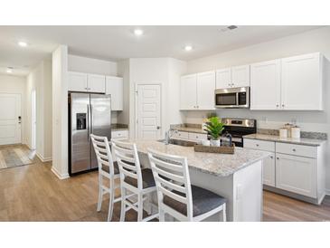Bright kitchen features white cabinets, stainless steel appliances, and granite countertops at 2076 Victory Way # 570, Myrtle Beach, SC 29579