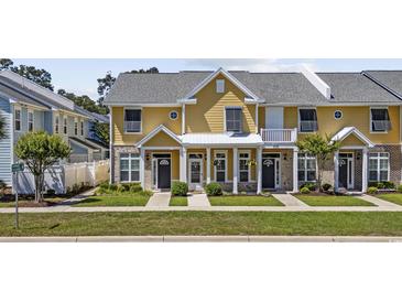 Inviting yellow townhouse featuring a well-manicured lawn and charming front porch at 3550 Pampas Dr. # 2, Myrtle Beach, SC 29577