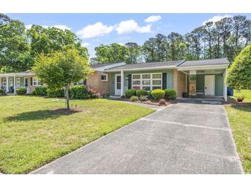 Charming single-story home with a brick and green exterior, carport, and well-maintained landscaping at 558 Juniper Dr., Myrtle Beach, SC 29577