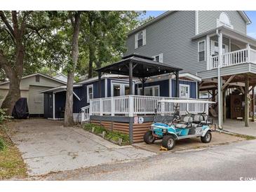 Charming beach home featuring a welcoming porch area and a convenient golf cart for easy transportation at 6001- 1771 S Kings Highway, Myrtle Beach, SC 29575