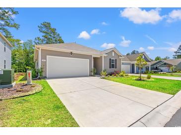 Charming single-story home with a wide driveway, attached garage, and beautifully landscaped front yard at 747 Gryffindor Dr., Longs, SC 29568