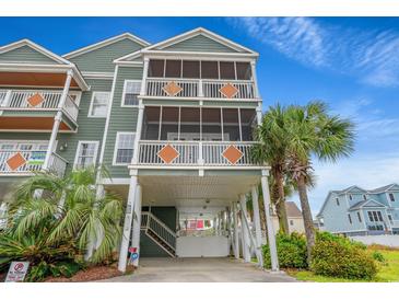 Three-story beach house with dual screened porches, covered parking, palm trees, and light-green siding at 113 B Vista Dr., Murrells Inlet, SC 29576