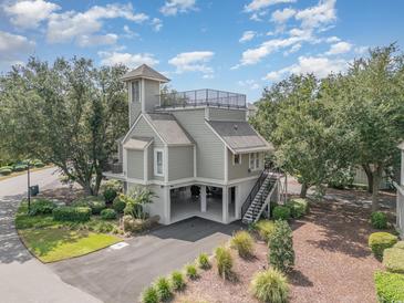Beautiful coastal home featuring elevated construction, a tower, roof deck, and meticulously landscaped grounds at 1608 Harbor Dr., North Myrtle Beach, SC 29582