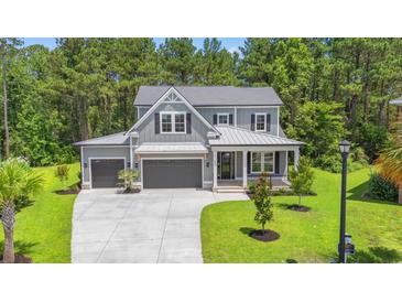 Charming two-story home with three-car garage, manicured lawn, and lush trees in the background at 209 Bouquets Green Way, Myrtle Beach, SC 29579
