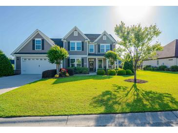 Charming two-story home with a well-manicured lawn, lush landscaping, and a welcoming front entrance at 304 San Martin Ct., Longs, SC 29568