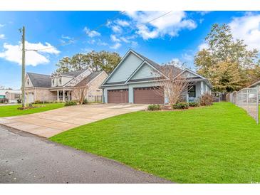 Charming light blue home with a two-car garage and a well-manicured lawn under a bright blue sky at 460 Boundary Ave. # A & B, Murrells Inlet, SC 29576