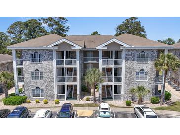 Attractive condo complex featuring a charming grey brick facade and multiple private balconies at 4771 Wild Iris Dr. # 103, Myrtle Beach, SC 29577