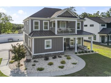 Charming two-story home with a covered porch, balcony, manicured landscaping, and appealing curb appeal at 4862 Mill Pond Rd., Myrtle Beach, SC 29588