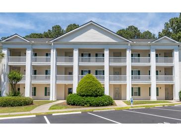 Attractive condo building featuring classic white pillars, multiple balconies and a landscaped walkway entrance at 5000 Windsor Green Way # 102, Myrtle Beach, SC 29579
