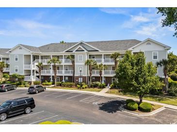 Attractive condo complex featuring palm trees, a gray color palette and ample parking at 5801 Oyster Catcher Dr. # 1214, North Myrtle Beach, SC 29582
