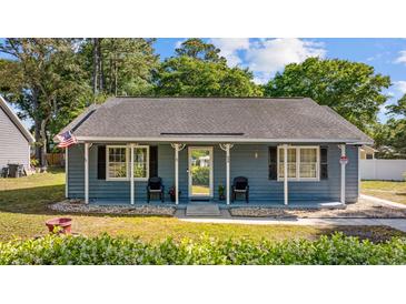 Charming single-story home featuring a covered front porch, blue siding, and well-manicured landscaping at 844 Wachesaw Rd., Murrells Inlet, SC 29576