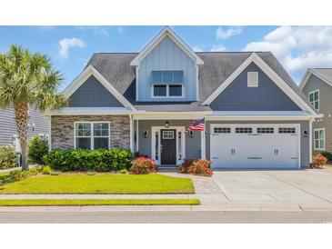 Charming two-story home featuring stone accents, gray siding, well-manicured lawn, and an attached two-car garage at 1136 Doubloon Dr., North Myrtle Beach, SC 29582