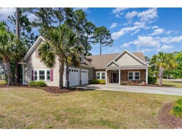 Charming home with a two-car garage, palm trees, and a well-manicured lawn at 1800 Wood Stork Dr., Conway, SC 29526