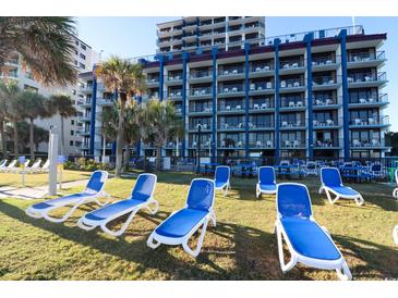 Relaxing resort featuring multiple floors, lawn, palm trees and many lounge chairs at 201 77Th Ave. N # 828, Myrtle Beach, SC 29572