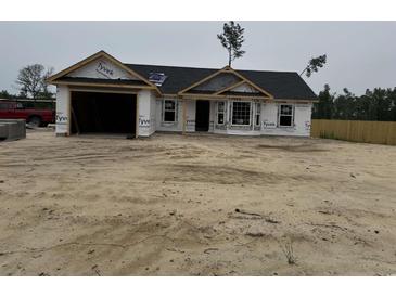 New construction home featuring a garage and windows, covered in Tyvek house wrap at 2186 Mineral Springs Rd., Conway, SC 29527
