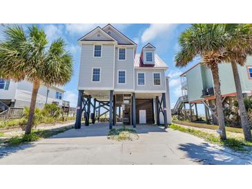 Charming stilt home with a red metal roof and light gray siding, surrounded by palm trees on a sunny day at 324 S Waccamaw Dr., Garden City Beach, SC 29576